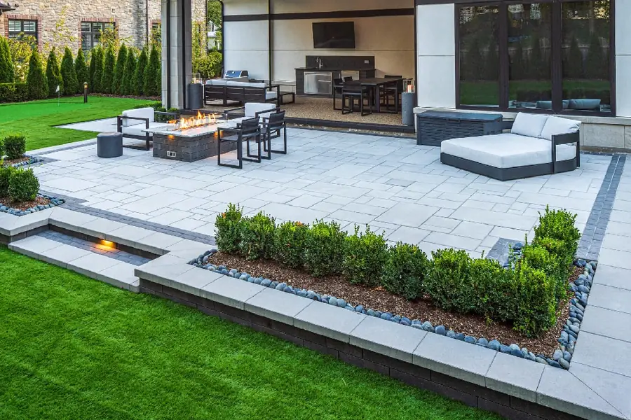 Aerial view of a paver patio with a fire pit and lounge chairs